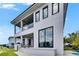 Modern two-story home with gray facade, glass balcony, and covered outdoor space at 6526 Simone Shores Cir, Apollo Beach, FL 33572