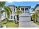 Stunning two-story home with black trimmed windows, tropical landscaping, and a three-car garage at 6526 Simone Shores Cir, Apollo Beach, FL 33572