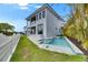 A luxurious pool with a spa sits near the home's covered patio on a manicured lawn at 6526 Simone Shores Cir, Apollo Beach, FL 33572
