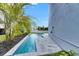 A long, private pool is situated in a garden with a white fence separating yards at 6526 Simone Shores Cir, Apollo Beach, FL 33572