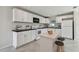 White kitchen featuring modern appliances, ample cabinet space, and a central island with seating at 6604 2Nd Ne Ave, Bradenton, FL 34208