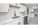 Bright kitchen showcasing white cabinetry, stainless steel sink, and modern fixtures at 6804 Tierra Verde St, Port Richey, FL 34668