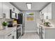 Well-lit kitchen featuring white cabinets, stainless steel appliances, and sleek countertops at 6804 Tierra Verde St, Port Richey, FL 34668