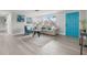 Cozy living room with a stylish sofa, a vibrant blue door, and plenty of natural light at 6804 Tierra Verde St, Port Richey, FL 34668