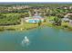Community pool and clubhouse on a lake with fountain and pier, surrounded by green lawns and mature trees at 6918 Potomac Cir, Riverview, FL 33578