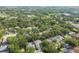 A wide aerial view displays homes among nature, near a lush green field and a community pond at 6918 Potomac Cir, Riverview, FL 33578