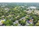 A stunning aerial view showcases a neighborhood surrounded by mature trees and lush greenery at 6918 Potomac Cir, Riverview, FL 33578