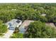 Aerial view of a home in a tree-filled neighborhood, featuring a pool and solar panels at 6918 Potomac Cir, Riverview, FL 33578