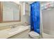Bright bathroom featuring white cabinets and counters, and blue decorative shower curtain at 6918 Potomac Cir, Riverview, FL 33578