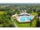 Aerial view of a community pool with a sand volleyball court and many amenities in a well-maintained landscape at 6918 Potomac Cir, Riverview, FL 33578