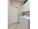 Bright Laundry room with white appliances, tiled flooring, and white storage shelves at 6918 Potomac Cir, Riverview, FL 33578