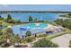 High angle shot of community pool and clubhouse with a volleyball court and lake view, ideal for recreation and relaxation at 6918 Potomac Cir, Riverview, FL 33578