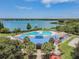 Aerial shot of community pool and clubhouse with ample lounge seating, set against a backdrop of a beautiful lake at 6918 Potomac Cir, Riverview, FL 33578