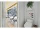 Cozy powder room with toilet, shelving and view of lanai at 6918 Potomac Cir, Riverview, FL 33578