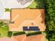 Aerial view of the home featuring a tile roof with solar panels, surrounded by lush greenery at 6928 Cozumel Ct, Land O Lakes, FL 34637