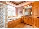 Bright bathroom featuring a garden tub, large window, and wooden vanity with granite countertop at 6928 Cozumel Ct, Land O Lakes, FL 34637