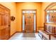 Bright foyer featuring tile flooring, a wooden front door with sidelights, and a bench at 6928 Cozumel Ct, Land O Lakes, FL 34637