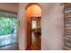 Hallway features a stone accent wall, wood floors, an arched entry and leads to a bedroom and an outdoor porch at 6928 Cozumel Ct, Land O Lakes, FL 34637