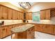 This is a large kitchen with beautiful wood cabinets, granite countertops and tile flooring with a large center island at 6928 Cozumel Ct, Land O Lakes, FL 34637