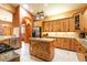 A large kitchen featuring custom wood cabinetry, granite counters, island with seating and modern stainless steel appliances at 6928 Cozumel Ct, Land O Lakes, FL 34637