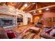 Living room featuring stone fireplace, wood floors, beamed ceilings, skylights, comfortable furniture at 6928 Cozumel Ct, Land O Lakes, FL 34637