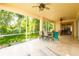Screened patio with tile flooring, ceiling fans, and a view of the lush backyard at 6928 Cozumel Ct, Land O Lakes, FL 34637