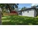 View of backyard with lawn, gray exterior home, wood fence and covered patio at 7011 N 15Th St, Tampa, FL 33610