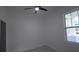 Bright bedroom featuring a ceiling fan, a window, and white walls at 7011 N 15Th St, Tampa, FL 33610
