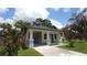 Exterior front view of home featuring a covered porch and a well-manicured lawn at 7011 N 15Th St, Tampa, FL 33610