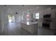 Bright open floor plan featuring kitchen with island, stainless appliances, and door to outdoor patio at 7011 N 15Th St, Tampa, FL 33610