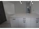Island with quartz counters and white cabinets in a modern and open kitchen design at 7011 N 15Th St, Tampa, FL 33610