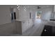 Modern open floor plan featuring kitchen with large island and stainless appliances that flows into the living area at 7011 N 15Th St, Tampa, FL 33610