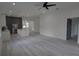 Open-concept living room featuring modern gray cabinets, stainless steel appliances, and light wood floors at 7011 N 15Th St, Tampa, FL 33610