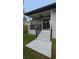 View of a home's covered patio with steps leading to the lawn and featuring a ceiling fan at 7011 N 15Th St, Tampa, FL 33610