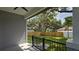 A covered patio with ceiling fan offers views of a large fenced backyard with mature trees at 7011 N 15Th St, Tampa, FL 33610