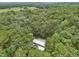 House featuring a metal roof, nestled among mature trees in a natural setting at 7189 Griffin Rd, Brooksville, FL 34601