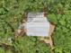 Aerial view of the home featuring a metal roof surrounded by mature trees at 7189 Griffin Rd, Brooksville, FL 34601