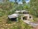 A house with a carport and a shed on the side, surrounded by greenery at 7189 Griffin Rd, Brooksville, FL 34601