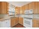 Bright kitchen with wood cabinets, white appliances and lighting at 7189 Griffin Rd, Brooksville, FL 34601