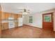 Kitchen featuring white appliances, wooden cabinets, tile flooring, a window, and a wood door at 7189 Griffin Rd, Brooksville, FL 34601