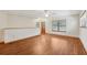 Spacious living room features wood-look flooring, a ceiling fan, natural light from a window, and a wooden door at 7189 Griffin Rd, Brooksville, FL 34601