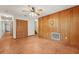 Living room features wood-paneled accent wall, tile flooring, ceiling fan, and ample windows at 7189 Griffin Rd, Brooksville, FL 34601
