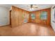 Living room features wood-paneled accent wall, tile flooring, windows, and a wooden door at 7189 Griffin Rd, Brooksville, FL 34601