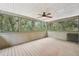 Relaxing screened-in porch with wood floors, a ceiling fan, and views of surrounding trees at 7189 Griffin Rd, Brooksville, FL 34601