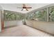 Relaxing screened-in porch with wood floors, a ceiling fan, and views of surrounding trees at 7189 Griffin Rd, Brooksville, FL 34601