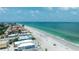 Expansive aerial view of beachfront houses nestled along a pristine sandy beach and clear turquoise waters at 722 Gulf Blvd, Indian Rocks Beach, FL 33785