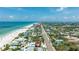 Expansive aerial view of a beachfront neighborhood with a pristine sandy beach and clear blue ocean at 722 Gulf Blvd, Indian Rocks Beach, FL 33785