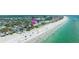 Stunning aerial view of beachfront homes with direct access to a beautiful sandy beach and turquoise water at 722 Gulf Blvd, Indian Rocks Beach, FL 33785
