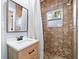 This bathroom has earth-tone tile shower with a window and modern vanity at 722 Gulf Blvd, Indian Rocks Beach, FL 33785