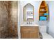 Bathroom featuring a brown tiled shower, wooden vanity with sink, an ornate mirror, and a decorative rowboat shelf at 722 Gulf Blvd, Indian Rocks Beach, FL 33785